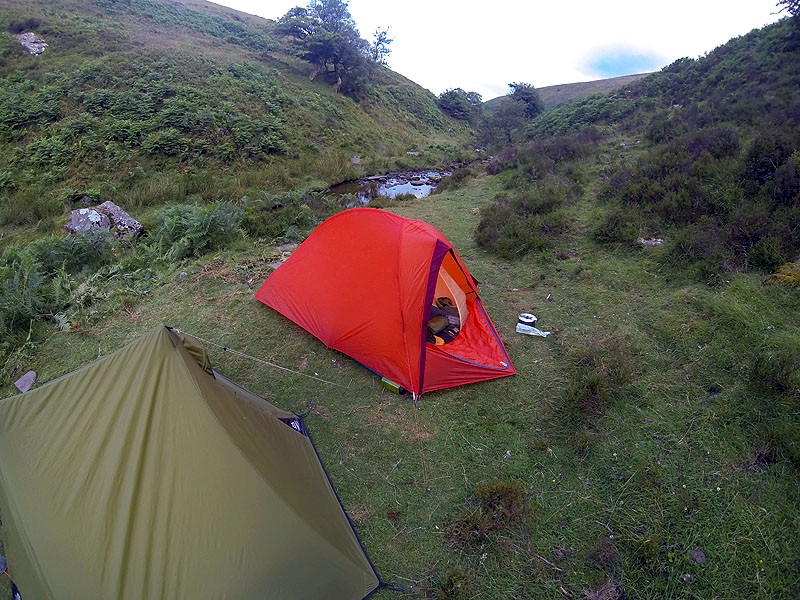 Image showing the bright Orange Vaude Hogan UL Argon pitched next to the modest green MSR tent.
