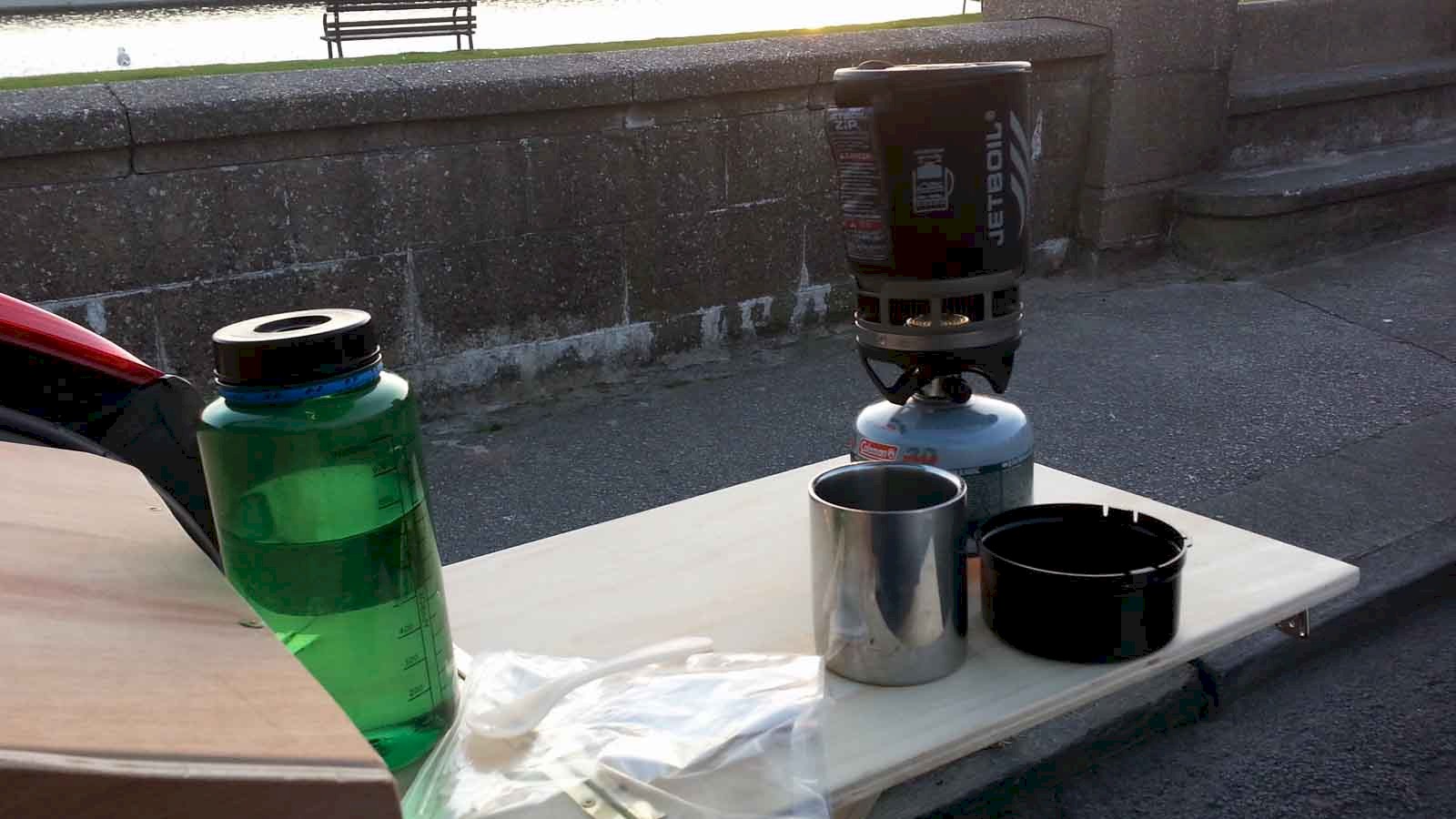 Picture showing the set up Jetboil Zip next to a 1l Nalgene bottle on a wooden table at the back of the car.