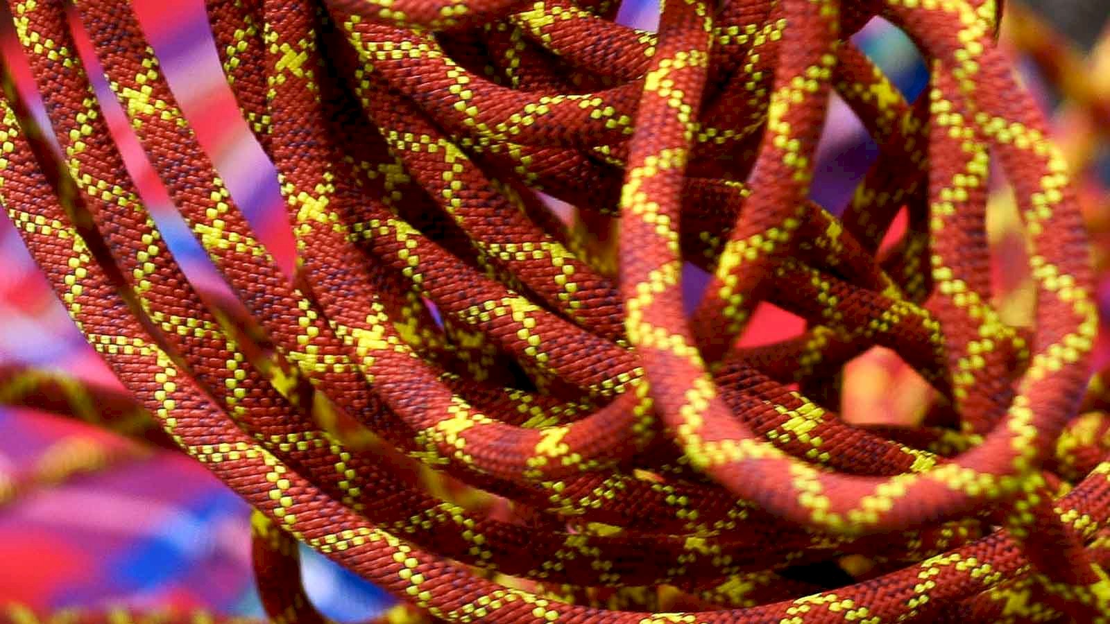 Close up image of red dynamic climbing rope with a yellow cross pattern.